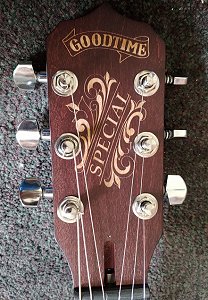 The Headstock on an Artisan Special 6-string banjo, with a classic engraving carved into the wood. Click for bigger photo.
