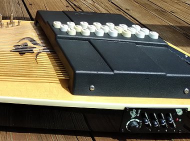 An OS45E with active pickup and EQ discontinued about 2003.  Unfortunately, Oscar Schmidt didn't add any reinforcement to this product when the factory notched into the frame to install the battery/EQ module, with the result that Oscar Schmidt aftermarket pickup with tiny volume and tone controls and a 1/8-inch jack. Click for bigger photo.
