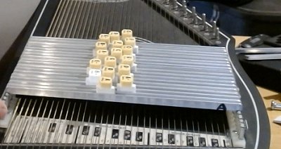 Exposed chord bars show you that the buttons just sit in a slot.  They can slide around easily, but they can also fall out easily.